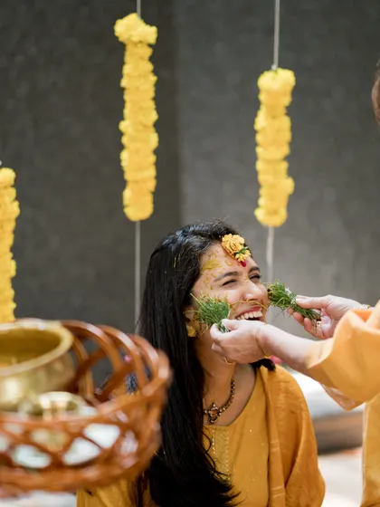 A joyful moment during the Haldi ceremony, where family members apply turmeric paste, a tradition symbolizing blessings and purification.