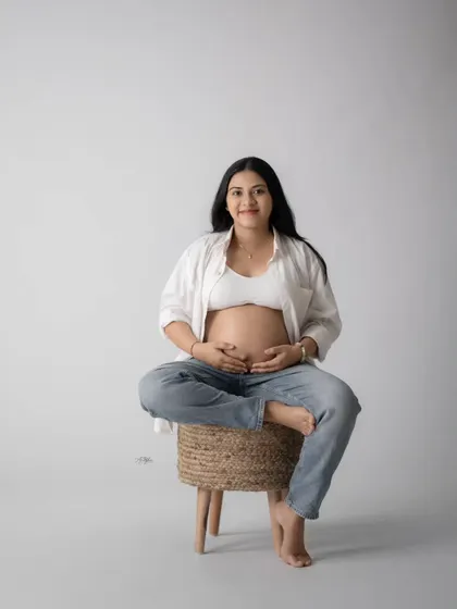 A modern and casual studio look, with the mom-to-be showing off her bare bump in jeans and an open white shirt. This style is relaxed and beautiful.