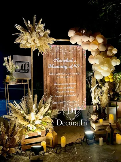 A personalized welcome sign for "Aanchal's Meaning of 40," set against a rustic wood-panel design and surrounded by pampas grass and balloons.