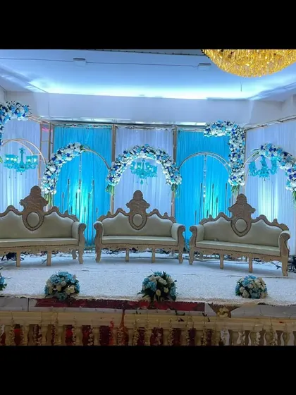 A stunning blue and white themed stage decoration at Palm Beach banquet. The multiple arches and matching floral arrangements create a cohesive and visually striking design.
