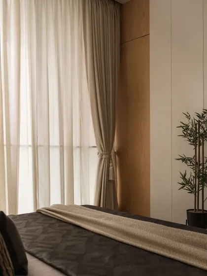 Details matter in creating a sanctuary. The way light filters through sheer curtains, the texture of a fluted wardrobe, and the addition of a simple plant all contribute to a feeling of quiet luxury and calm.