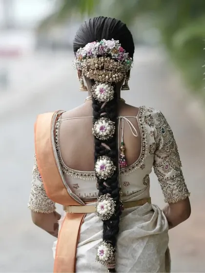 A bride's fairytale moment, her intricate hairstyle and custom blouse creating a look of pure magic.