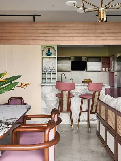 This view showcases the architectural details, including the curved, textured archway that defines the transition from the dining area to the kitchen, adding a soft, organic element to the space.