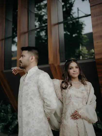 A stylish, modern portrait of an engaged couple. The clean architectural lines and their elegant attire create a sophisticated and timeless look.