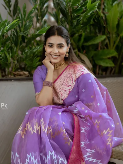 A beautiful portrait showcasing the intricate design of the purple organza saree and the delicate embroidery on the blouse.
