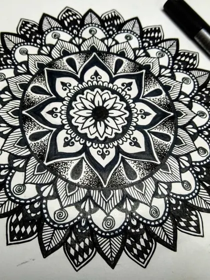 This black and white mandala showcases a variety of patterns, from leaves to dots. Each section is carefully planned to create a balanced and harmonious design.