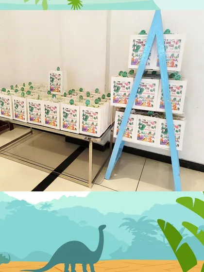 For a dinosaur-themed party, I set up this display of gift bags on a table and a small easel. It shows how the return gifts can be a part of the party decor.