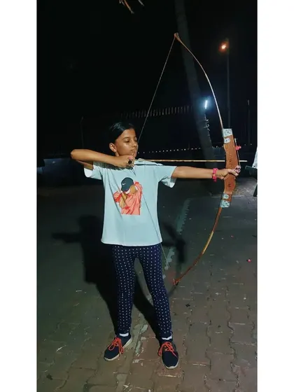 This young archer is building her skills one arrow at a time during an evening session.