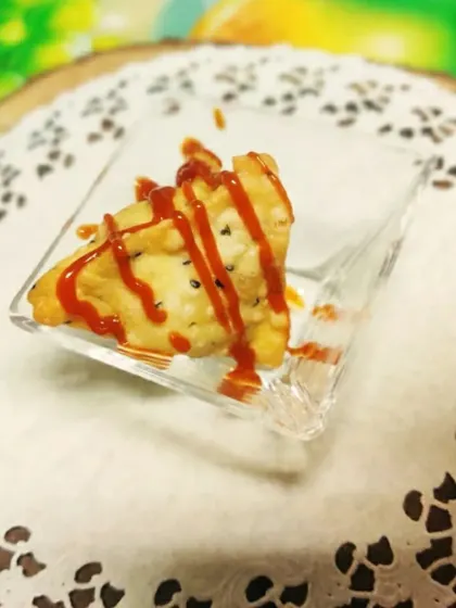 A single, perfectly crisp samosa served in a small glass dish. This shows how we can present even simple snacks in an elegant way for your events.