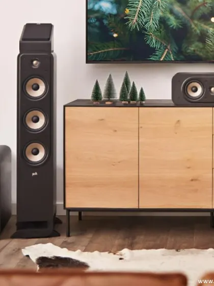 A close-up of a Polk home theater system ready for the holidays. The combination of a tower speaker, subwoofer, and center channel ensures that your Christmas carols and movies sound their absolute best.