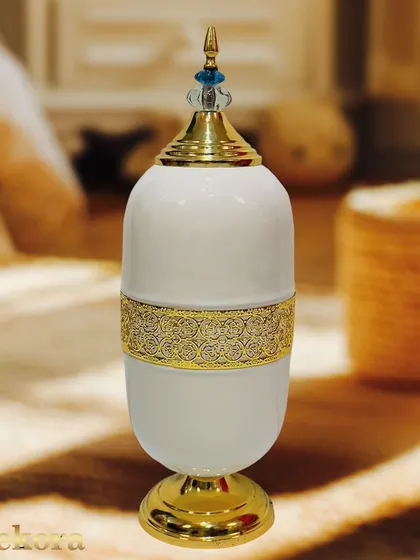 This luxury showpiece is a variation of our decorative urn, presented here in white and gold. Its elegant form and polished finish make it a versatile piece that complements both modern and traditional interiors.