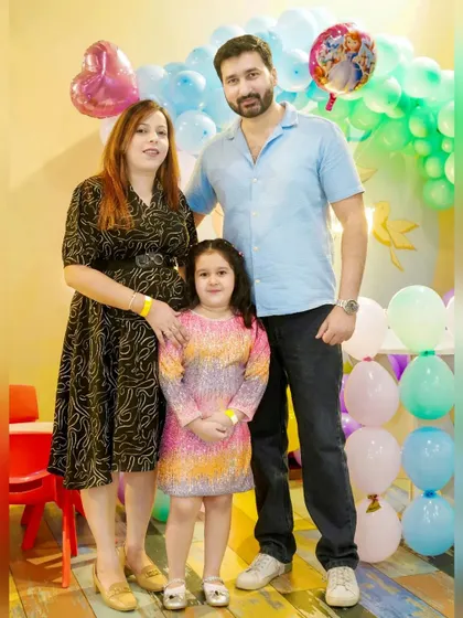 A family of three posing for a photo at their daughter's birthday party. We provide a mix of posed and candid shots to fully document your event.