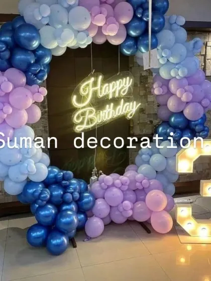 A birthday setup for a 3rd birthday using a full balloon ring in shades of blue and purple, with a large marquee number '3'.