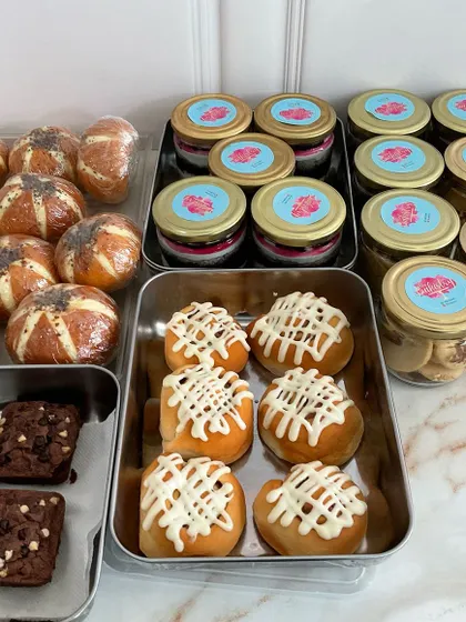 A glimpse of the variety I offer for festive gifting and individual orders. This image showcases some of the items I prepare, including savory Korean buns, dessert jars, brownies, and cinnamon rolls.