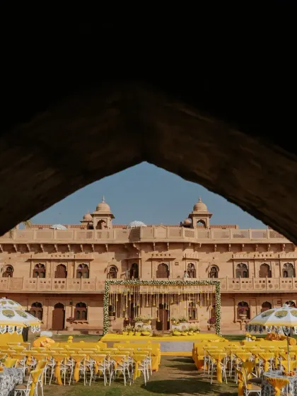 A view of the majestic Rajasthan palace through an archway, showcasing the stunning venue for a royal Haldi ceremony.