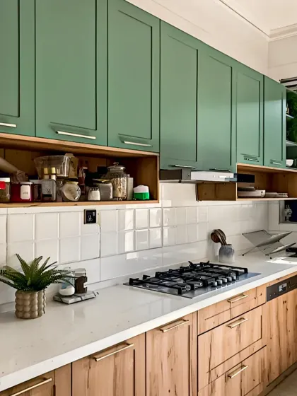 We combined sage green upper cabinets with natural wood lower cabinets for a fresh, contemporary look. The open shelf provides easy access to frequently used spices, blending practicality with modern kitchen aesthetics.