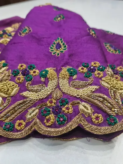 A detailed close-up of the peacock motif on the sleeve cuff. Notice the intricate zardosi work that gives the peacock its form and the colorful floral accents surrounding it.