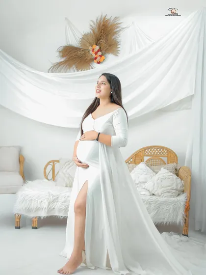 This portrait is all about softness and light. Set in my bright, airy studio, the mother-to-be in a flowing white gown looks serene and angelic, capturing the pure, hopeful feeling of this special time.