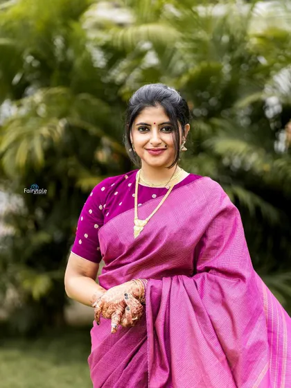 A portrait in a pink silk saree, showcasing the beautiful fabric and jewelry.