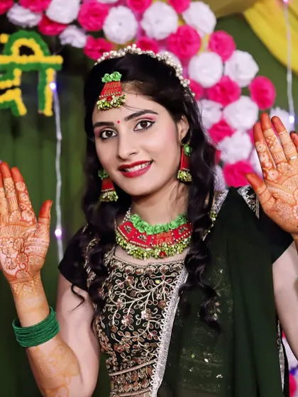 A lovely bride from her mehndi ceremony, happily showing her hands. The initial stain is bright orange, which darkens beautifully over the next day.