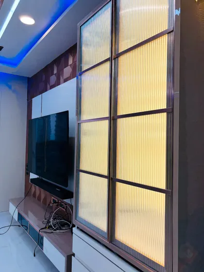 This mandir is cleverly concealed behind fluted glass doors that are part of a larger living room storage unit.