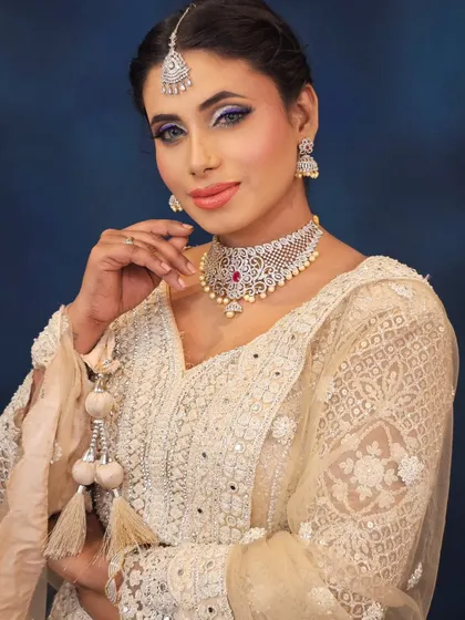 A confident and modern bridal look. The purple eyeliner adds a pop of color that is unexpected yet stunning with the white outfit.