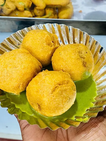 A plate of hot, fluffy Aloo Bondas served with my signature green chutney. I fry every batch in fresh oil, ensuring a perfect, non-greasy snack every time, especially on a rainy Bangalore evening.