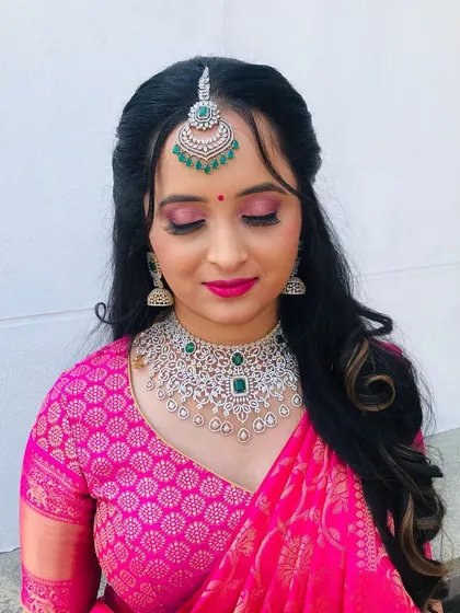 A beautiful shot with her eyes closed, showcasing the soft pink eyeshadow and flawless base.