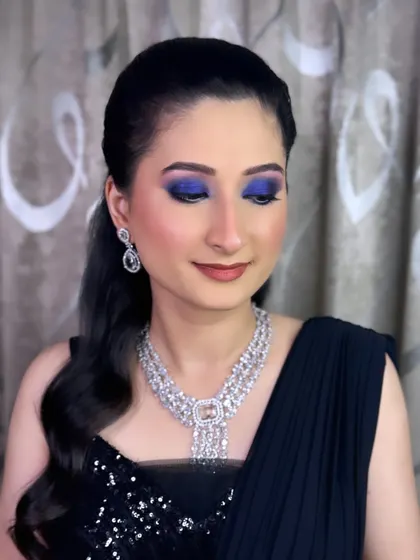 A bold and glamorous cocktail night look. We created a dramatic blue smokey eye paired with a neutral lip and glowing skin for a fashion-forward bride.