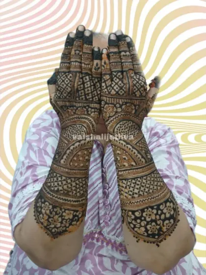 A full view of a stunning bridal back-hand design. The patterns are dense and elaborate, creating a rich tapestry of floral and traditional motifs.