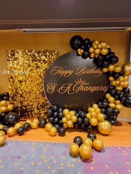 A full, unobstructed view of the luxurious black and gold 95th birthday backdrop.