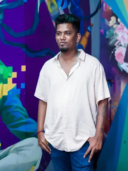 Posing against a colorful graffiti wall. My style is influenced by urban art and culture, which also reflects in my music choices.