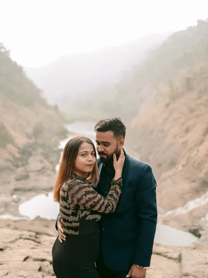 An intimate pre-wedding portrait with a stunning valley view in the background, highlighting the adventurous side of the couple.