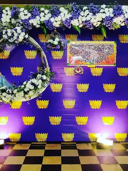 An elegant floral decor for baby Aravinda's naming ceremony. We used a royal blue backdrop with a lotus print, a floral-decorated cradle, and a frame of white and blue flowers.