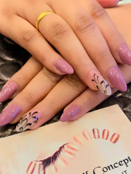 An elegant design on long almond nails. The solid mauve base is complemented by accent nails with intricate, hand-painted black patterns.