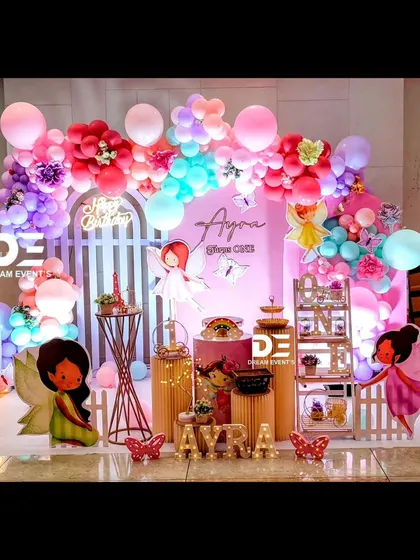 A wide shot of Ayra's beautiful fairy-themed birthday party. The combination of bright colors, character cutouts, and layered backdrops makes for a stunning visual.