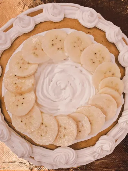 An overhead shot of the Peanut Butter and Banana cake, showing the beautiful swirl of frosting and neatly arranged banana slices.