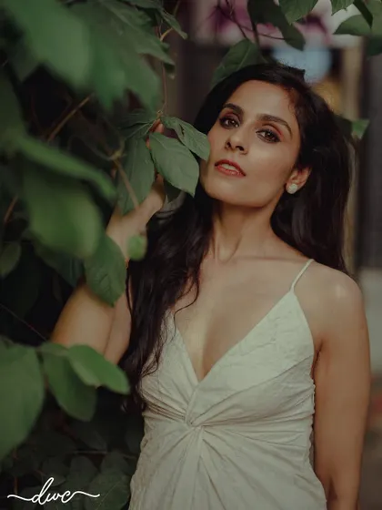 A stunning portrait of the bride-to-be, her natural beauty enhanced by the soft light and lush green leaves surrounding her.