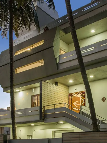 The exterior of a 10,000 sq. ft. residence in old Bangalore, where luxury is juxtaposed with simplicity. The design features a prominent cantilevered volume, creating a modern and powerful architectural statement.
