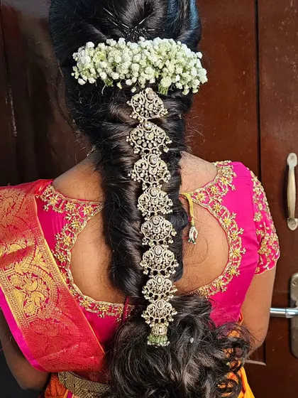 A South Indian bridal look is incomplete without the perfect hairstyle. Here is a classic bridal braid, intricately decorated with beautiful jada billai and fresh jasmine flowers for that authentic and fragrant touch.