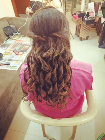 A simple half-up twist with voluminous curls. This is a classic party hairstyle that is quick to create and looks effortlessly elegant.