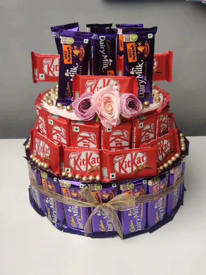 A three-tier chocolate cake made from KitKats and Dairy Milks. This is a fun and creative alternative to a traditional cake for any chocolate lover's celebration.