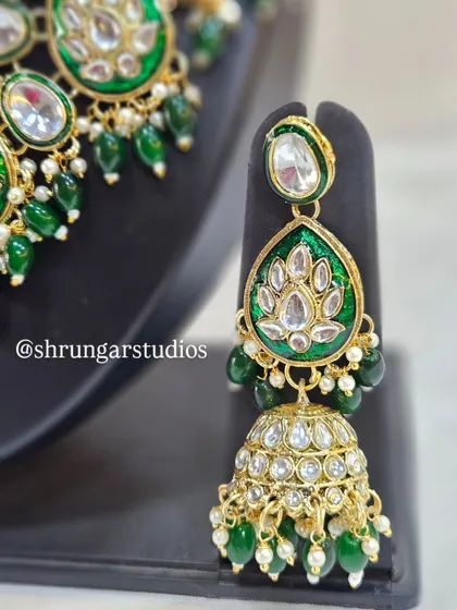 The matching jhumkas with green Meenakari work are just as stunning as the necklace.