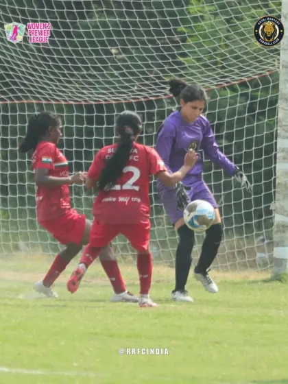 Our goalkeeper confidently collects the ball under pressure from opposing forwards, showcasing her bravery and safe hands.