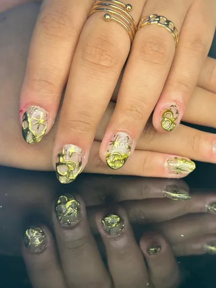 An intricate design with 3D sculpted gold art on a sheer, shimmery base.