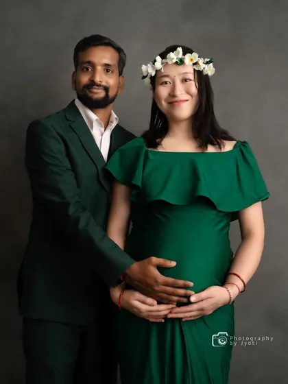 A formal studio portrait of an expecting couple, perfect for a classic and elegant maternity announcement.