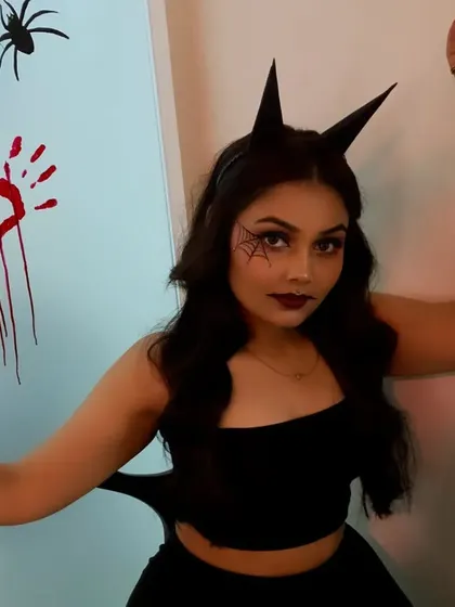 A playful and spooky pose for Halloween. The makeup is dark and dramatic, perfect for a costume party.