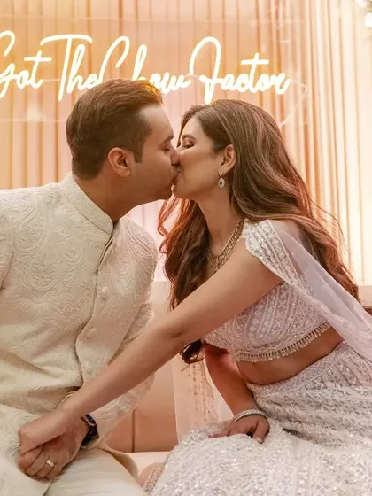 A sweet kiss during an engagement ceremony, with a custom neon sign in the background. A perfect blend of modern trends and timeless romance.