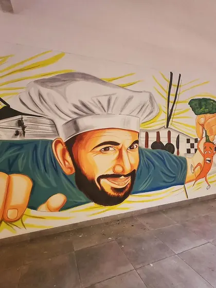 A wider shot of the chef mural, showing how he appears to be bursting out of the wall into the cafeteria space.