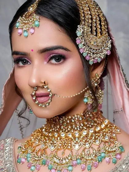 A direct, confident gaze from the bride. The makeup enhances her features with a pop of color on the eyes and a flawless complexion.